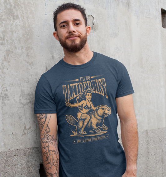 Man wearing a blue t-shirt with graphic design and text, standing against a concrete wall.